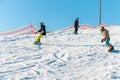 Logoisk. Belarus. 01.10.2023. Two teenage snowboarders with a coach go down the slope of a snow-covered mountain