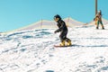 Logoisk. Belarus. 01.08.2023. Two teenage snowboarders go down the slope of a snow-covered mountain