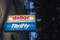 Logos of Dollar Rent a car and Thrifty Car rental in front of their local office. part of Hertz group, Dollar and Thrifty are car Royalty Free Stock Photo