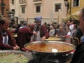 Chefs cooking paella, a typical dish of Valencia, during the festivities of San Mateo. Queue of people waiting for their turn.