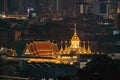 Loha Prasat, Wat Ratchanatda, and skyscraper buildings at night in Bangkok City, Thailand. Buddhist temples