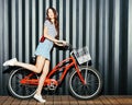 Loker long legged girl asian in a summer outfit, sneakers, cassette player and headphones posing and having fun with a vintage red Royalty Free Stock Photo