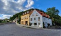 A quaint cobblestone street with two colorful restored historical houses
