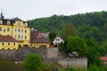 Loket, Czech Republic; 5/20/2019: Yellow building of St. Florian Brewery restaurant, with the stone wall at the foreground and Royalty Free Stock Photo