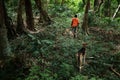 young local village tribe member man teenager walking with his dogs to the rainforest jungle to hunt some birds with his slingshot