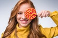 beautiful smiling redhead stylish girl holdig lollipop