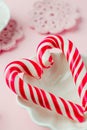 Lollipop candies like heart on pink pastel vintage background. Concept of sweet romantic senses.