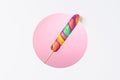 Lollipop candy on stick big colorful rainbow in a layered paper design with circle cut pink background Royalty Free Stock Photo