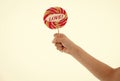 Lollipop with love lettering  on white. Candy on stick in hand. Sweet candy swirl. Valentines day concept. Food Royalty Free Stock Photo