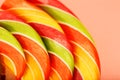 Lollipop multicolored close-up as background texture on pieces on pink background