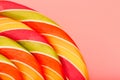 Lollipop multicolored close-up as background texture on pieces on pink background