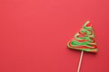 Lollipop in the shape of a christmas tree and red background. Copy space