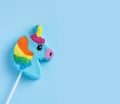 Lollipop unicorn on a blue background. Panorama, closeup. Trend