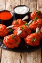 Lollipops deep-fried red chicken wings with sauces close-up on a slate board. Vertical Royalty Free Stock Photo