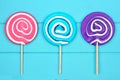 Lollipops in pink, blue and purple colors against blue wood Royalty Free Stock Photo