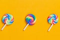 Lollipops are in a row. spiral candy. sweets on a yellow background. festive decoration