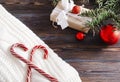 Lollipops on a white sweater, spruce branch,  Christmas balls, gift box on a wooden background Royalty Free Stock Photo