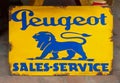 Vintage rusty Peugeot sales service sign 1936-1948. Blue lion logo and brand on yellow background.