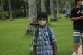 lombok, a child wears a medical mask and adheres to health protocols in a hotel garden, to protect him from, virus, Covit-19