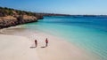 Lombok - A drone shot of a couple playing at the seashore of Pink Beach