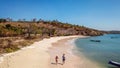 Lombok - A drone shot of a couple playing at the seashore of Pink Beach