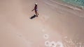 Lombok - A drone shot of a girl walking on a wet sand