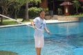 lombok, Indonesia, january 30, 2022, a hotel employee wearing a blue t-shirt is cleaning the swimming pool with a net stick