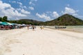 Holidaymakers and surfers on the golden tropical beach of Selong Belanak on the island of