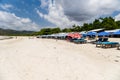 Holidaymakers and surfers on the golden tropical beach of Selong Belanak on the island of