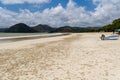 Holidaymakers and surfers on the golden tropical beach of Selong Belanak on the island of