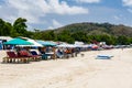 Holidaymakers and surfers on the golden tropical beach of Selong Belanak on the island of