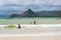 Surfers in the warm shallow water of Selong Belanak on the Indonesian island of Lombok