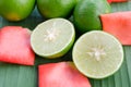 Lemons with slices and rose petals on banana leaf background Royalty Free Stock Photo