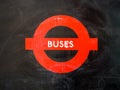 A London bus stop shelter red painted logo. Royalty Free Stock Photo