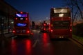 London buses, outside North Greenwich tube station at sunset.