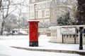 London classic red mailbox under the falling snow