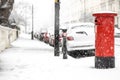 London classic red mailbox  under the falling snow Royalty Free Stock Photo