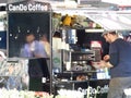 A barista prepares coffee on an outside stall on the hottest day of the year, London