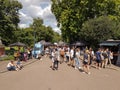 People crowd in street lined with food carts enjoying british summer and city life in Victoria Park