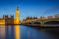 London, England - The Big Ben Clock Tower and Houses of Parliament with iconic red double-decker buses at city of westminster by Royalty Free Stock Photo