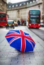 London, England - British umbrella at busy Regent Street with iconic red double-decker buses and black taxi Royalty Free Stock Photo