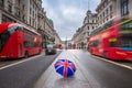 London, England - British umbrella at busy Regent Street with iconic red double-decker buses Royalty Free Stock Photo