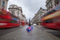 London, England - British umbrella at busy Regent Street with iconic red double-decker buses Royalty Free Stock Photo