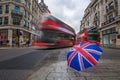 London, England - British umbrella at busy Regent Street with iconic red double-decker buses Royalty Free Stock Photo