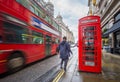 London, England - Iconic blurred red double-decker bus on the move with traditional red telephone box and walking man Royalty Free Stock Photo