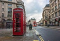 London, England - 15.03.2018: Iconic red telehone box near Piccadilly Circus with red double-decker bus Royalty Free Stock Photo