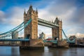 London, England - Iconic Tower Bridge with traditional red double-decker bus and skyscrapers of Bank District