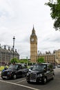 Two iconic black cabs in front of Big Ben tower