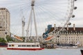 View of the entrance to the famous London ferris wheel called the London Eye, next to the River Thames on a cloudy summer day