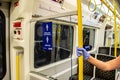 LONDON/ENGLAND- 2 June 2020: Passenger wearing disposable gloves, holding a hand rail on a London Underground tube train Royalty Free Stock Photo